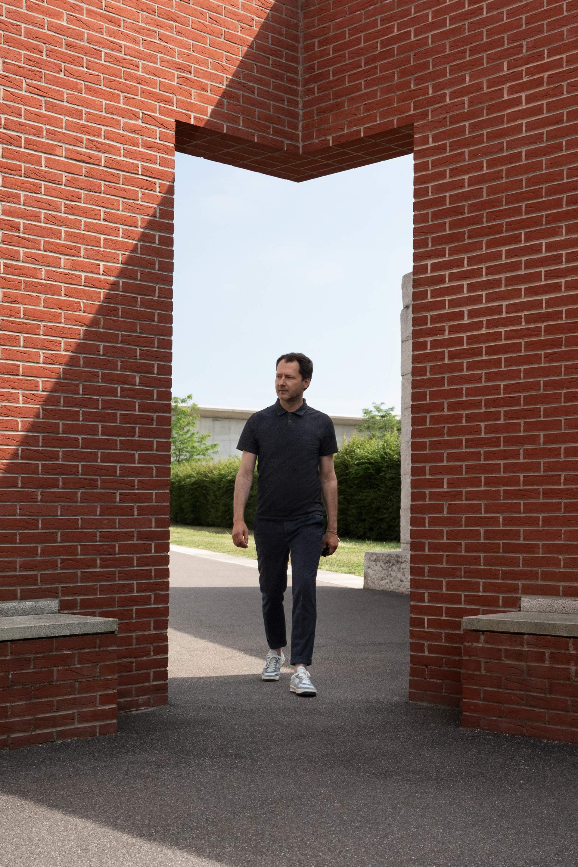 Mateo Kries loopt door de ingang van de promenade Álvaro-Siza op de campus Vitra.